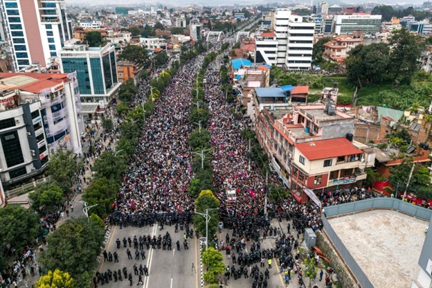 An aerial view shows demonstrators gathered outside Nepal’s Parliament during a protest in Kathmandu on September 8, 2025, condemning government social-media prohibitions and corruption. Nepal police opened fire, killing at least 19 people as thousands of young protesters demonstrated on September 8.